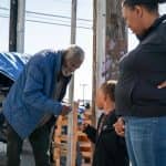 homeless man fist bumps boy